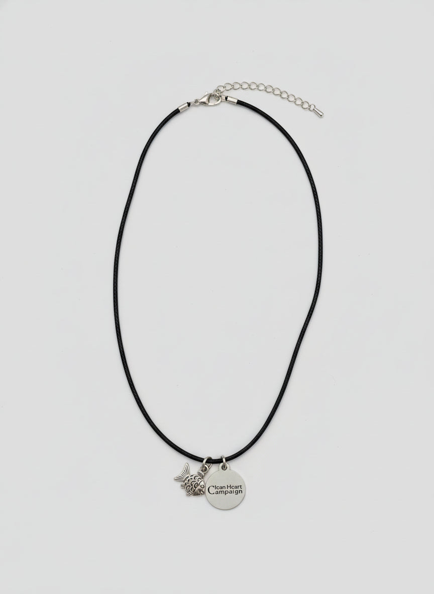 Black necklace with a pendant on a white surface